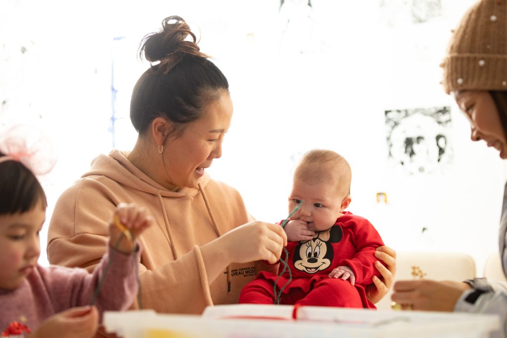 An image of a mother with a baby doing a craft activity