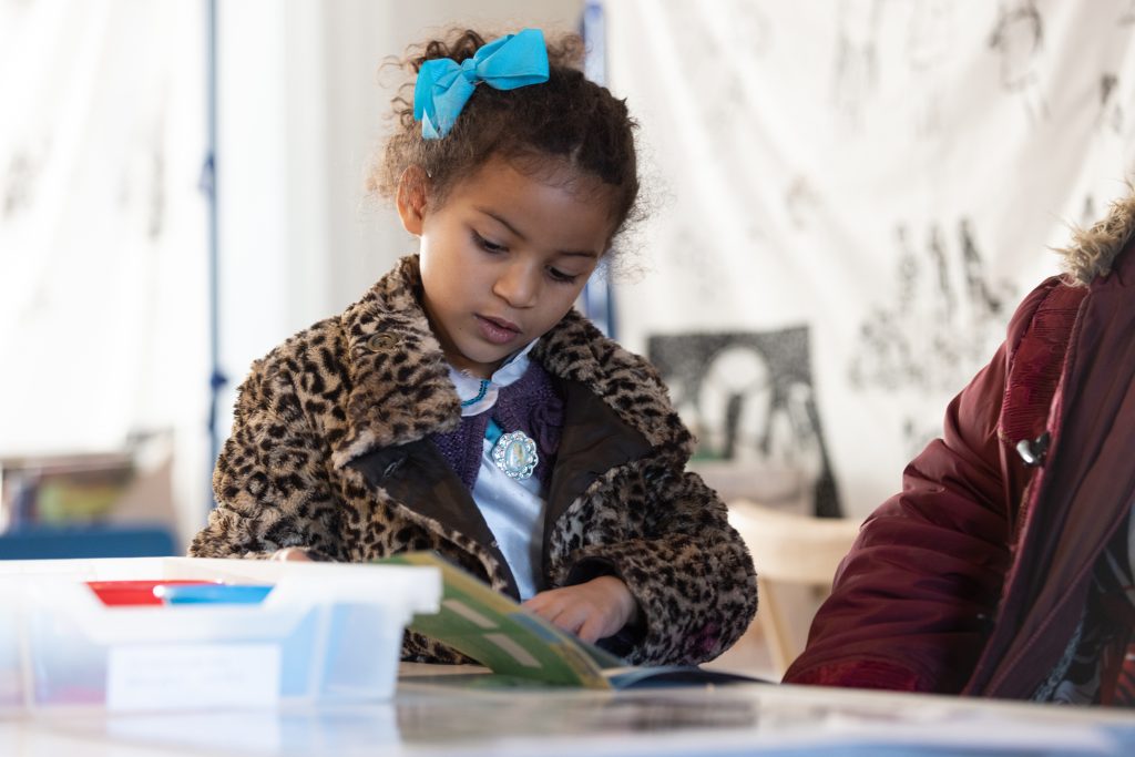 A little girl reads the Gallery's Family Trail