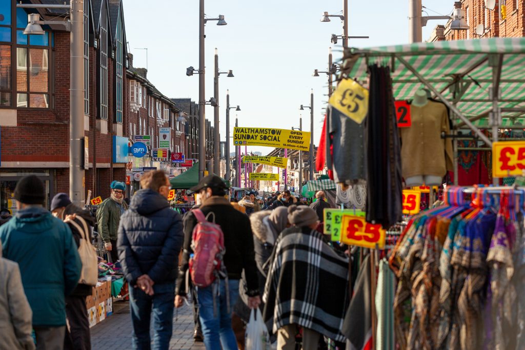 Walthamstow market. Image of street stalls and people walking down through the market.