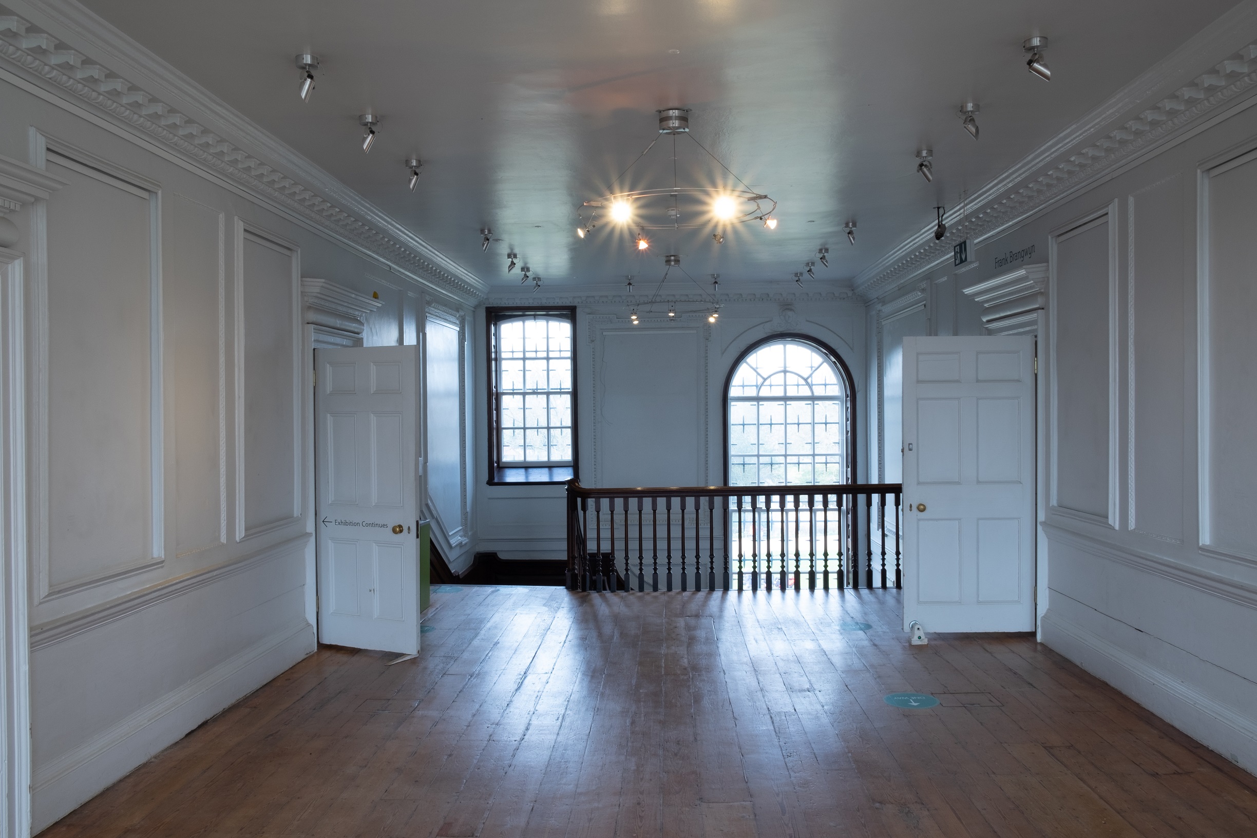 Upstairs landing space or Story Lounge at William Morris Gallery. Panelled white walls with wood floors.