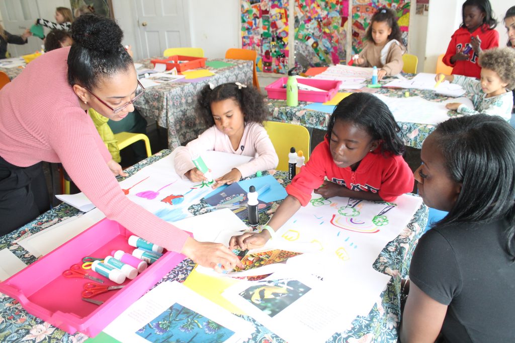 An artist works with a family on a craft activity.