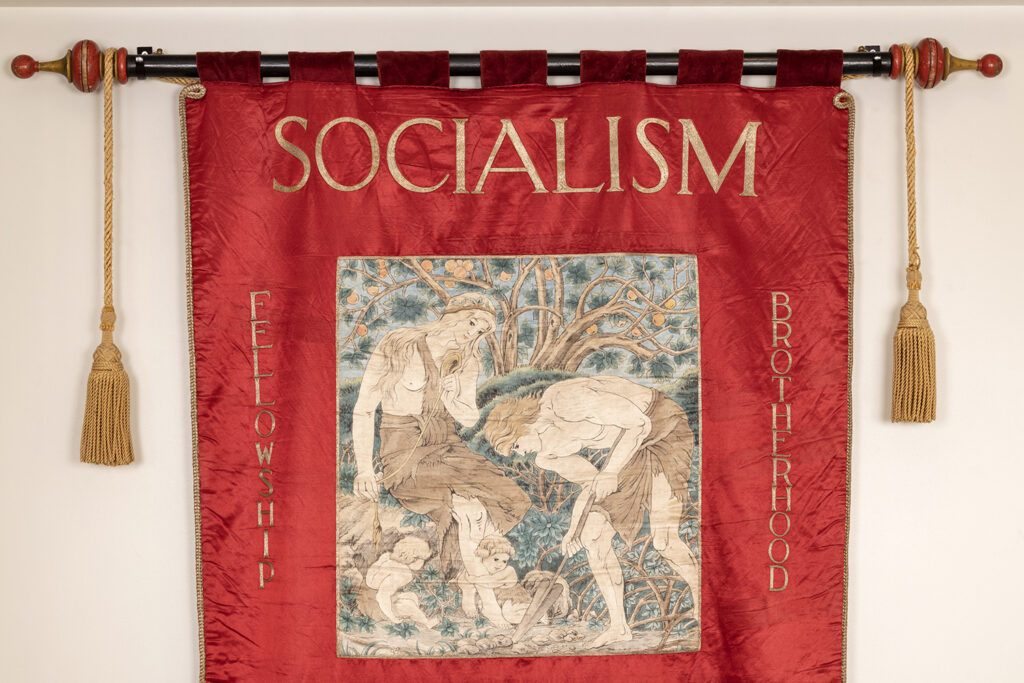 Embroidery detail from a socialist banner in red with an embroidered wording and image