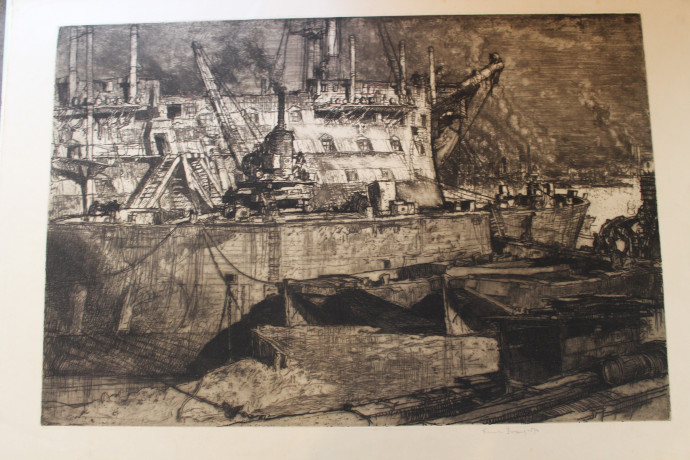 Floating docks foreground, merchantman with demoliton equipment moored beyond alongside hulk of old ship, stretch of water with shipping and distant factories background right