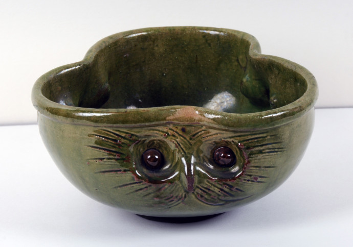 Green, trefoil shaped bowl decorated with the faces of three owls
