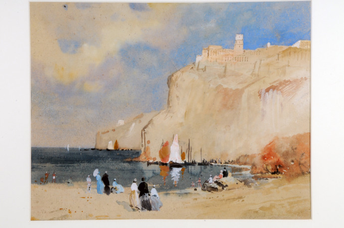 People on beach across bay  from cliffs