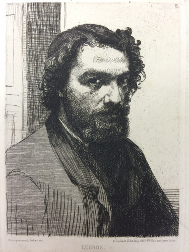 Head and shoulders portrait of man with beard and door open behind him