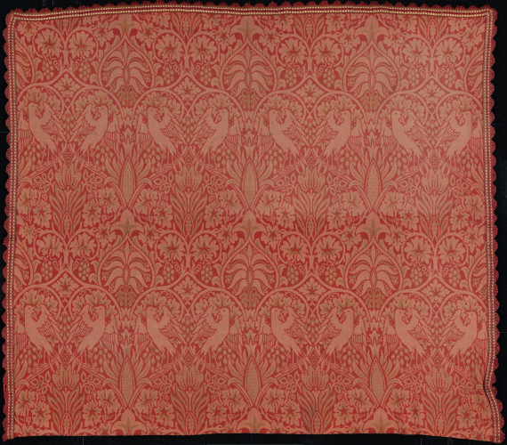 Square woven wool textile, warm red colour with intertwining pattern of birds and a vine