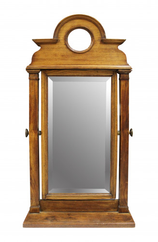 A table mirror with a wooden frame featuring a circular whole above the rectangular mirror surface