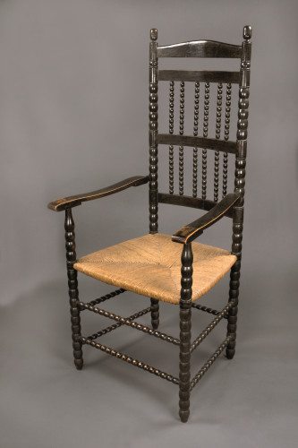 High-backed rush-seated ebonised armchair