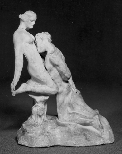 Two figure group in plaster of woman standing poised on one foot the other held up behind her with one hand, a man kneeling before her, his hands clasped behind his back, leaning forward and kissing her torso. Right view.