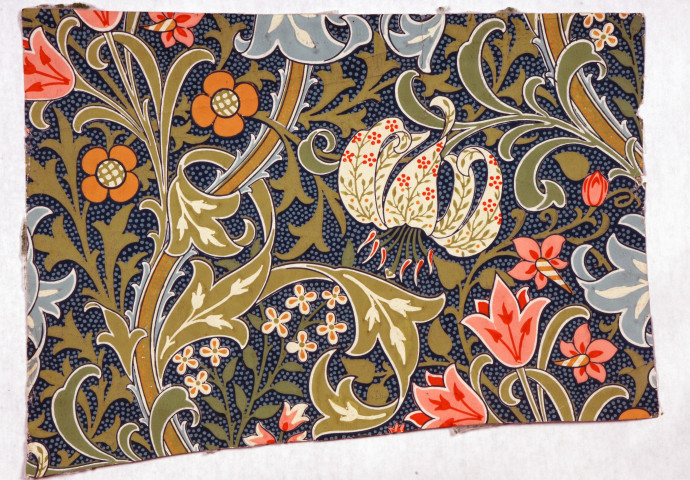 fragment of wallpaper with green pink orange and blue flowers on dark blue ground