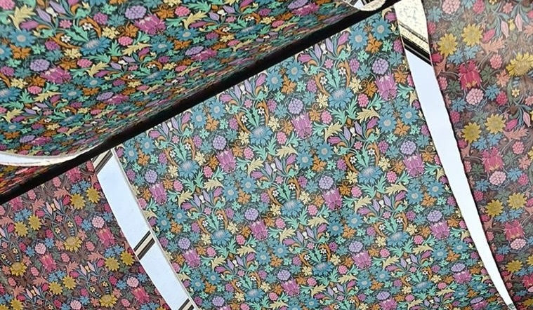 Brightly coloured patterned fabric hanging from the roof of William Morris Gallery