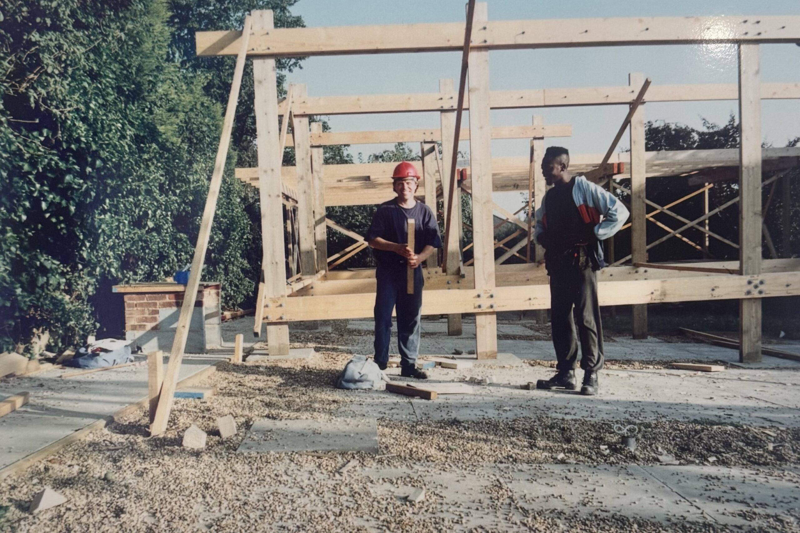 Two people building the framework of a house.